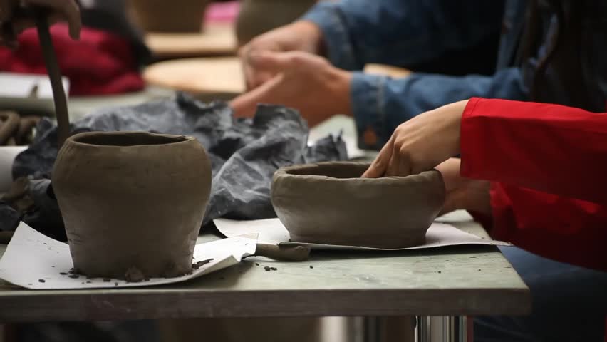 Pottery class workshop. Clay shaping on potter's wheel.
