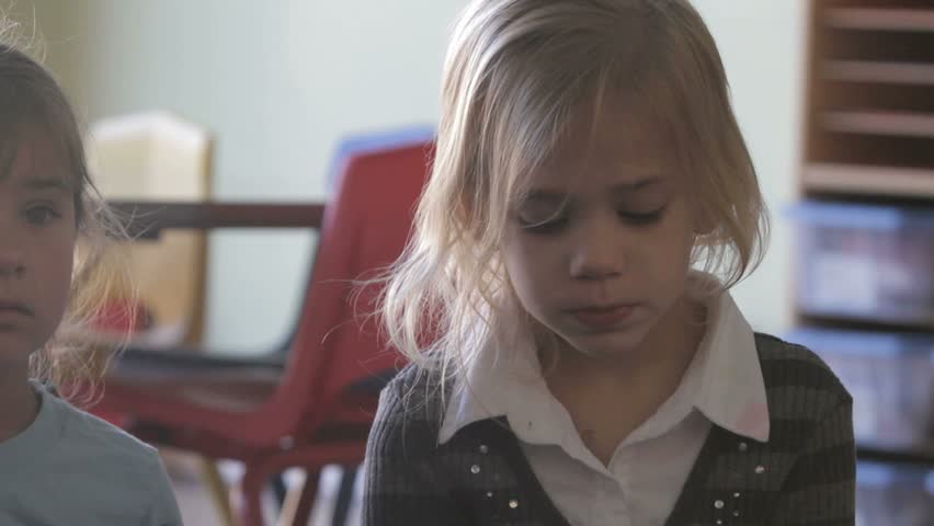 Little girl listening to her preschool teacher