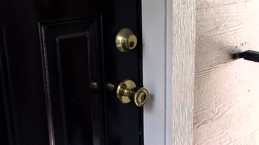 A man walking up to a door and knocking