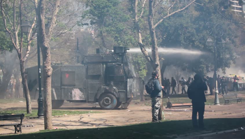 SANTIAGO, CHILE - SEPTEMBER 22: Water cannon truck disperse demonstrators during a student strike on September 22, 2011 in Santiago, Chile. Protesters demand the government to improve education quality.
