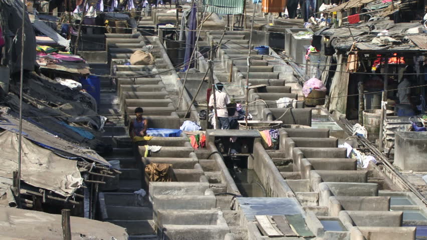 Mumbai, India - May 15, 2011: Men washing clothes in an outside laundry. Over 400 Million are classed as ultra poor in India. Poverty rates are higher than some East Asia countries such as Vietnam.