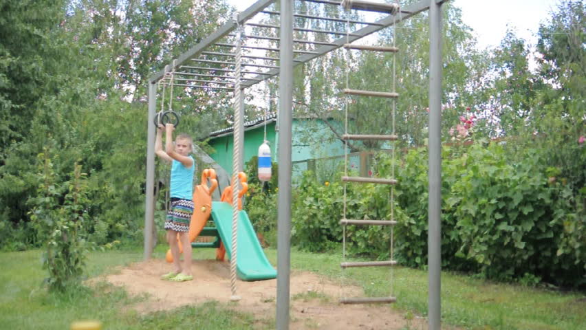 young boy exercising on gymnastic rings