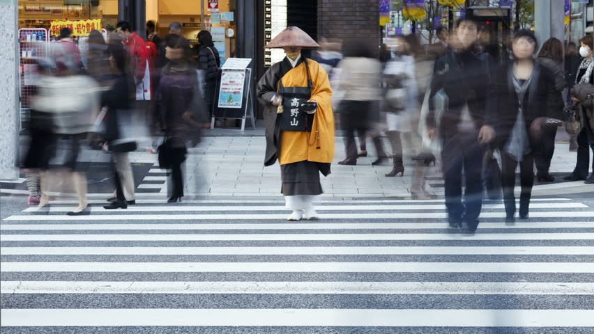 TOKYO, JAPAN - CIRCA MAY 2011: a Shinto priest seeking donations (Alms) crossing the street in the Ginza district