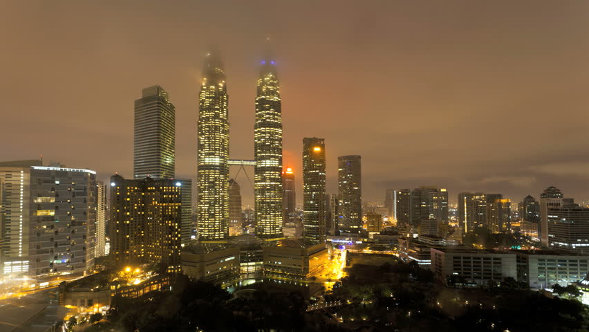 KUALA LUMPAR - CIRCA MAY 2011: dusk to dawn view of the Petronas Twin Towers and KLCC Park, Kuala Lumpur City Centre KLCC
