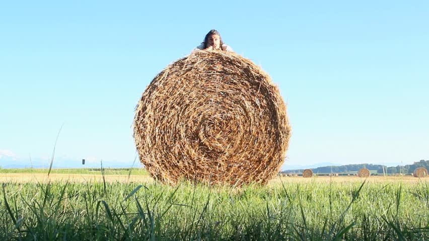 funny man dealing with a hay bale