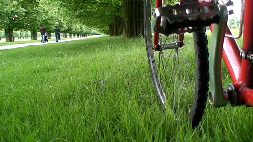 Pushing a bicycle through a park