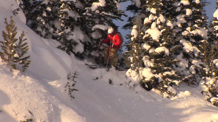Male skier drops into steep back-country terrain