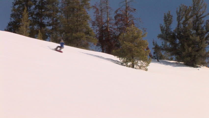Female snowboarder carving through back-country powder