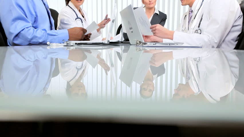Female financial advisor meeting medical team executives in hospital boardroom