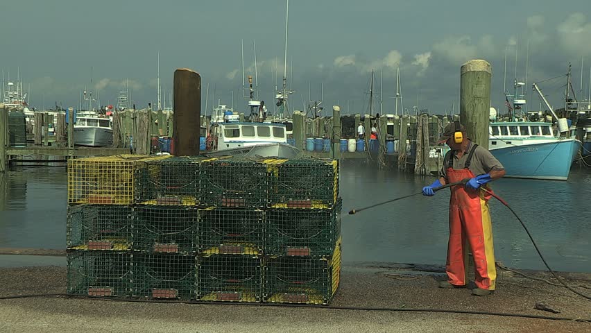 NEWPORT, RHODE ISLAND - CIRCA JULY 2010: Fisherman pressure washing lobster traps 
