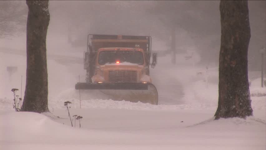 NEW ENGLAND - CIRCA JANUARY 2006: City snowplow plowing residential street in snowstorm