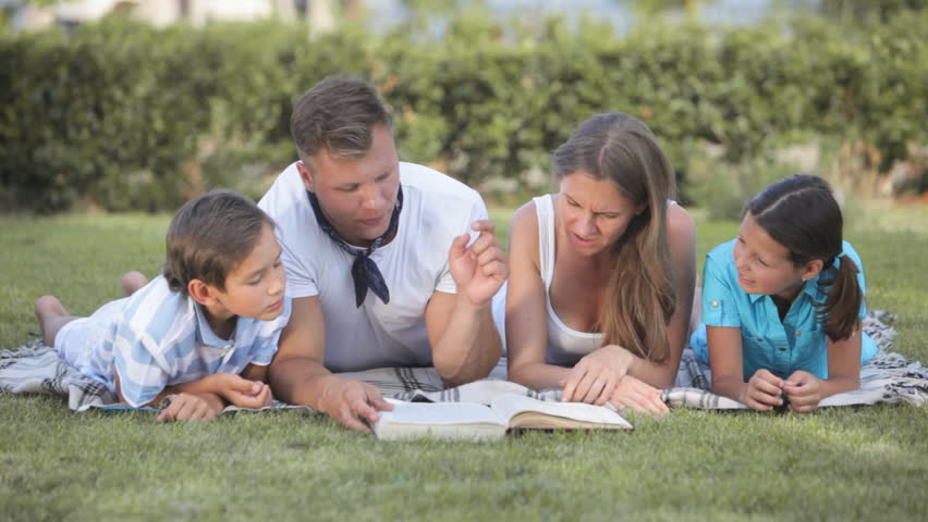 Dad reading an interesting story to his kids and wife
