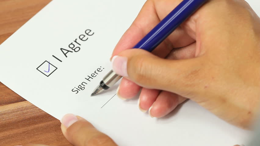 Female hand checking the "I agree" checkbox and applying a signature on the line below