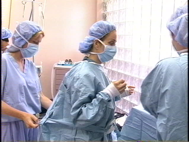 Doctor is putting on surgical gloves