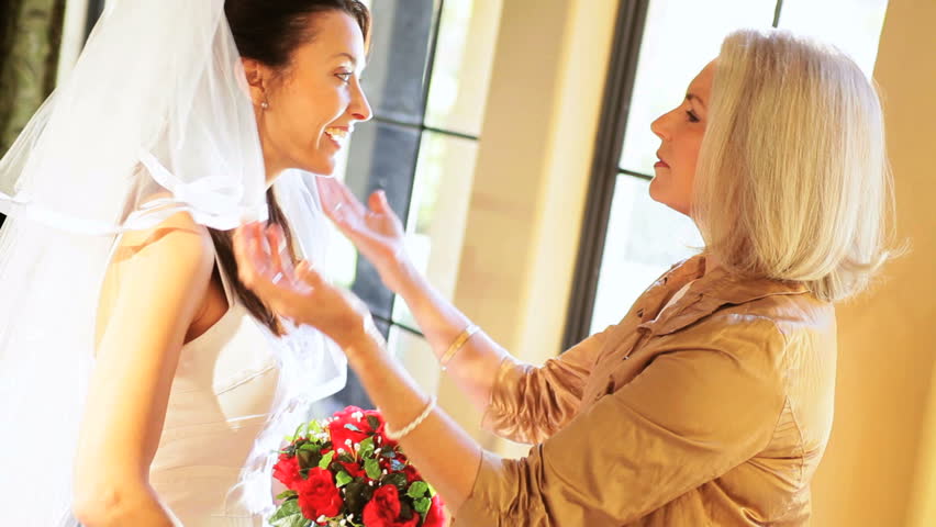 Brides mother reassuring daughter before wedding ceremony