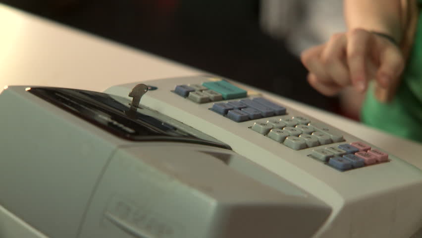 A human hand working a cash register and receiving money