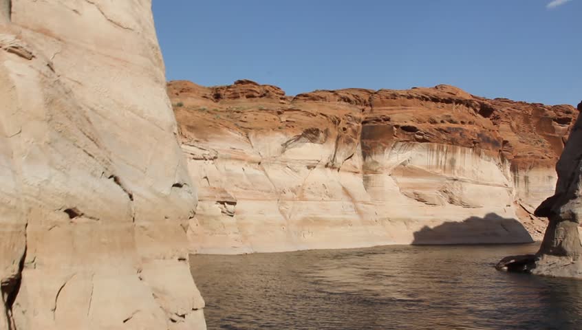 Cruising on the Colorado River between the towering rock walls of the Glen Canyon, toward the Glen Canyon Dam in Utah, USA is a main tourist and recreational attraction for the area.