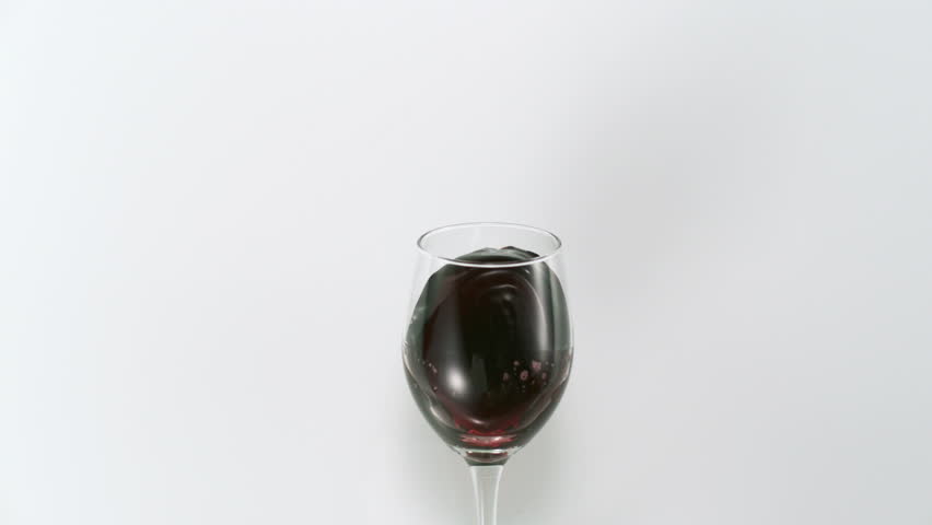 Red wine splashing out of glass shooting with high speed camera.