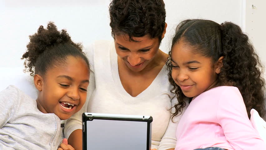 Ethnic mother cute young daughters close up using wireless tablet