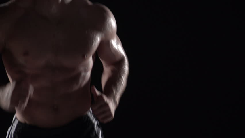 Muscular man running towards camera, torso shot left