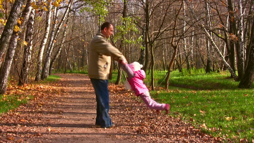 grandfather rotate child in autumn park 