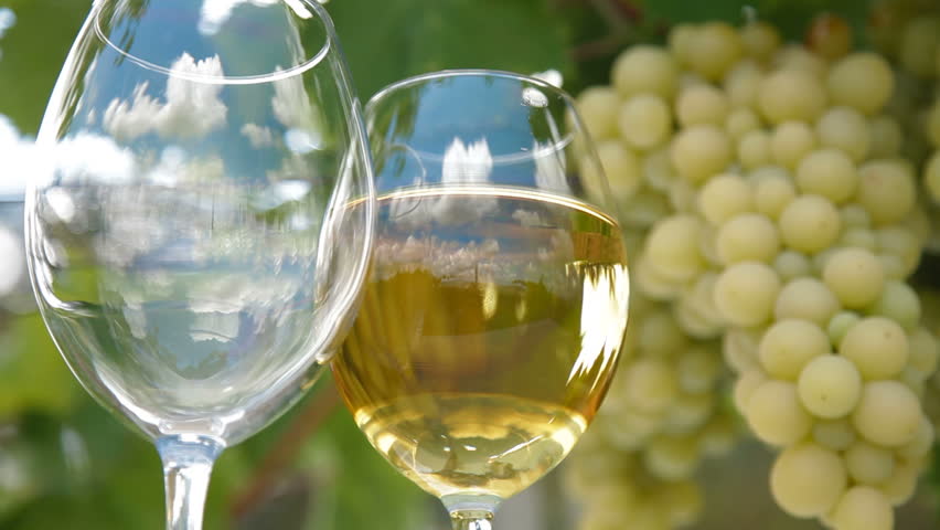 Blue sky with clouds reflected in the glass of wine