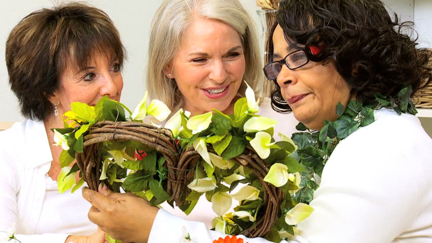 Attractive older ladies enjoying hobby time working with silk flowers home
