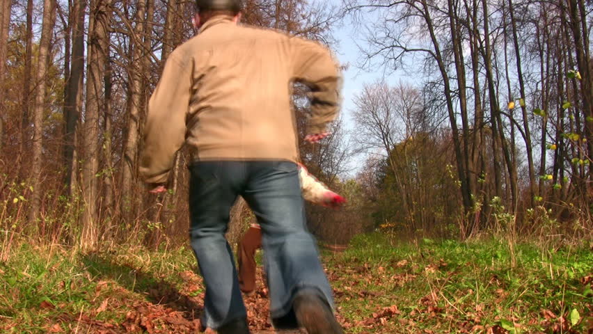 child and grandfather play football in park 