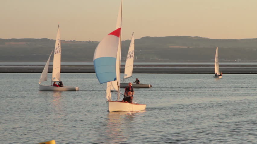 WEST KIRBY, WIRRAL/ENGLAND - AUGUST 9: Sailing crew stow spinnaker then round buoy on August 9, 2012 in West Kirby. The Marine Lake is a man made coastal lake fed by the sea at high tide.  