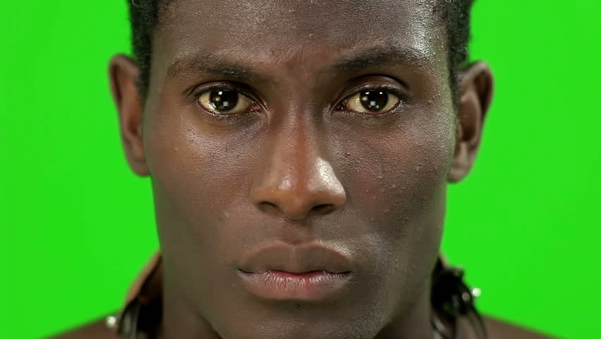 african young guy facing to the camera with a strong look in a chroma key