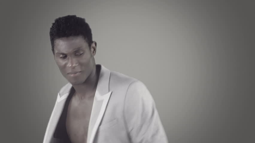 young african guy waving and dancing with a cool attitude on an elegant suit