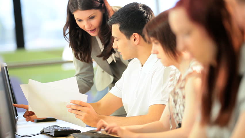 Teamwork of diverse male and female students focus on university project instruction Caucasian female teacher in campus library