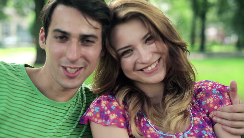 Happy couple in love sitting in the park

