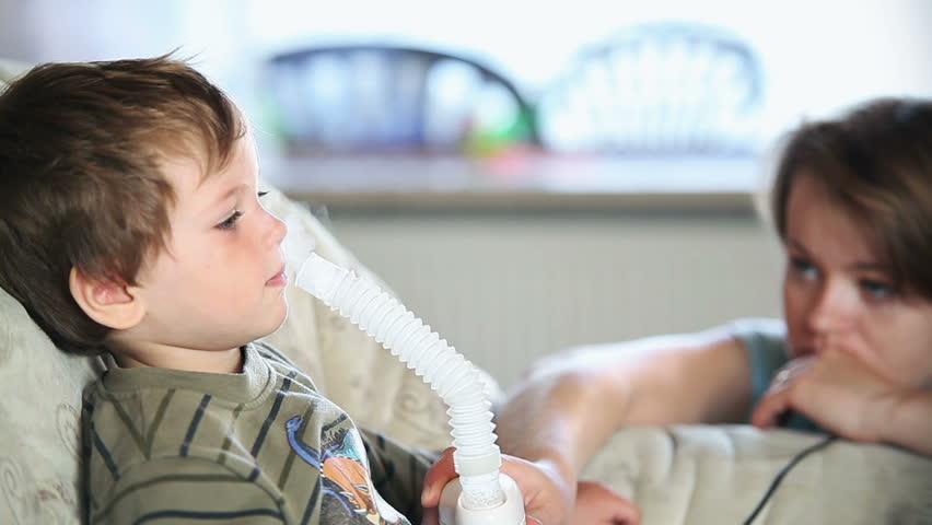 Little boy and mother using nebulizer to inhale medicine