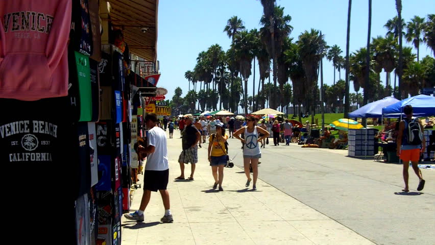 VENICE BEACH, CA - AUGUST 2: Tourists walking on the Venice Beach Boardwalk and looking at T-shirts and souvenirs on August 2, 2012 in Venice Beach, CA.