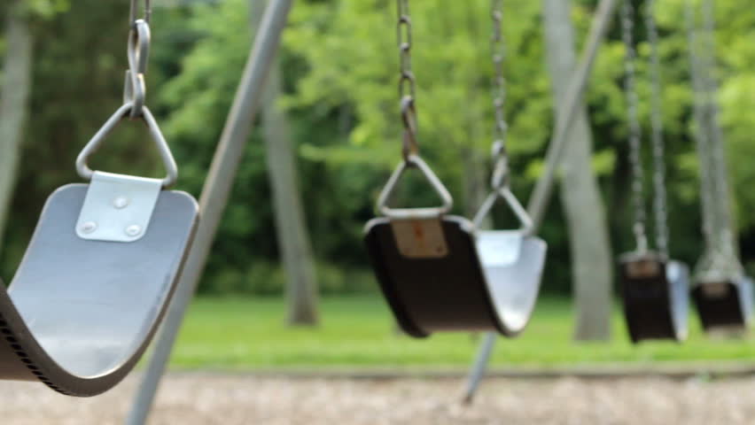 Empty swings swaying at playground