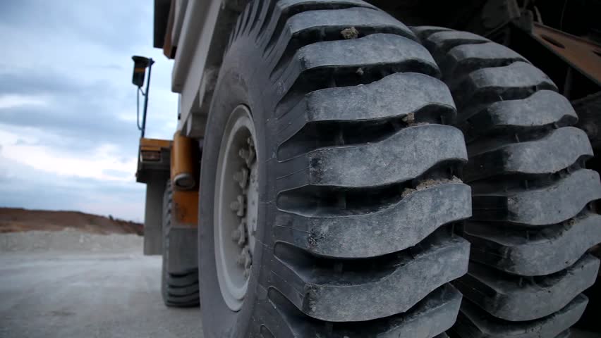Heavy mining dump trucks driving along the opencast