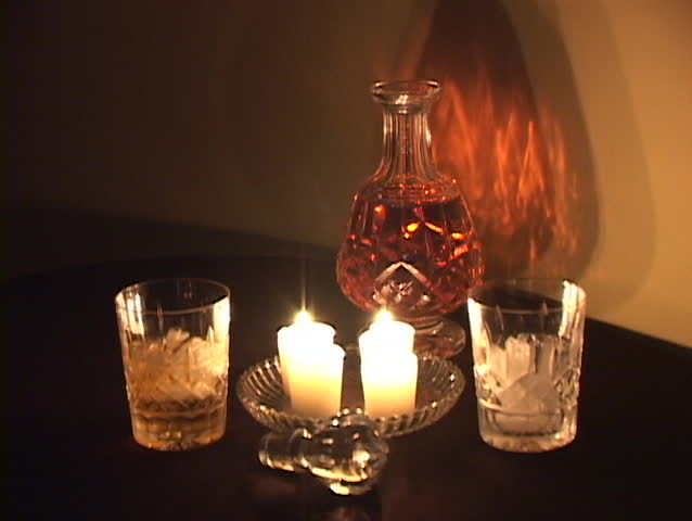 Fine crystal decanter and glasses with Scotch with candle light reflections