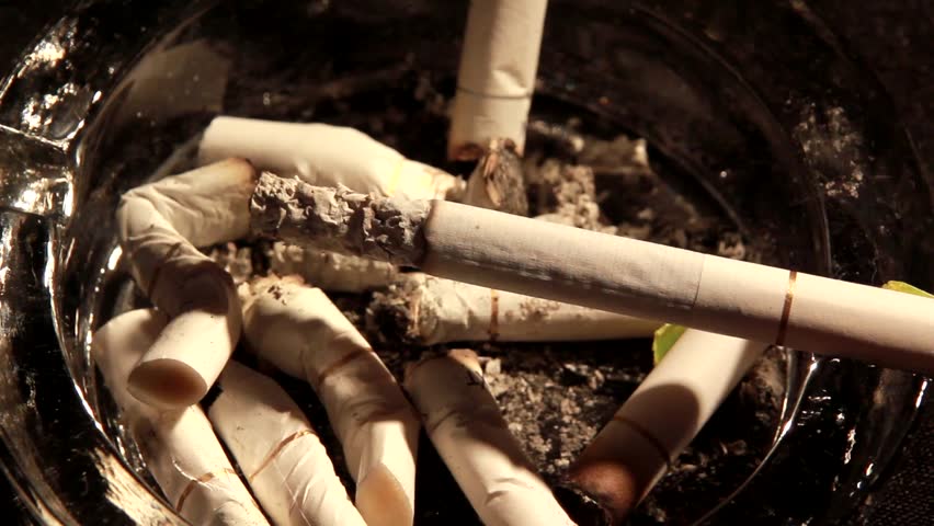 A burning cigarette in an ashtray -time lapse - close up
