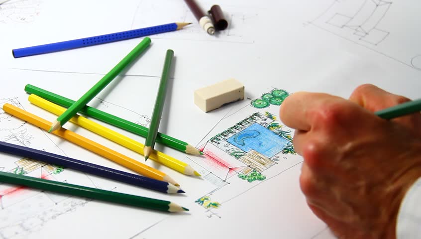 Man sketching on landscape architectural drawing.