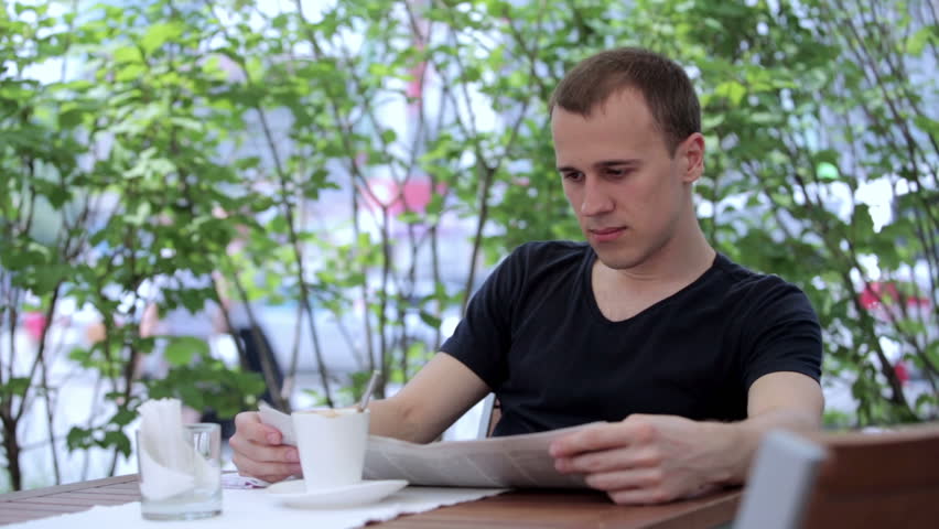 Man in summer cafe drinking coffee and coughs