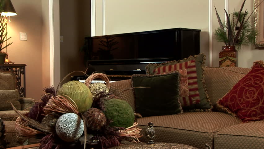A weary woman carrying wrapping paper and other items plops down on the sofa to rest