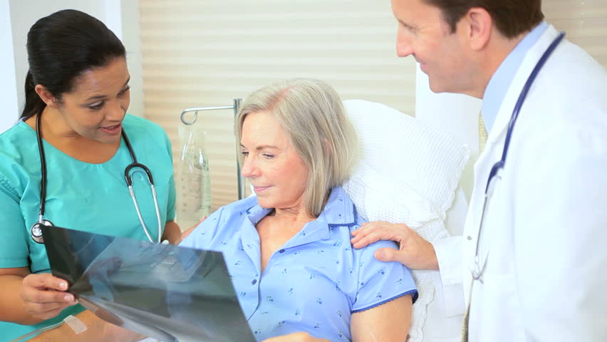 Hospital radiology staff discussing x-ray results older female patient