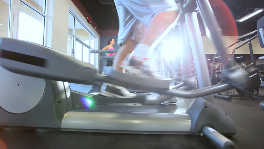 Legs only people working out on cross trainers in modern gym