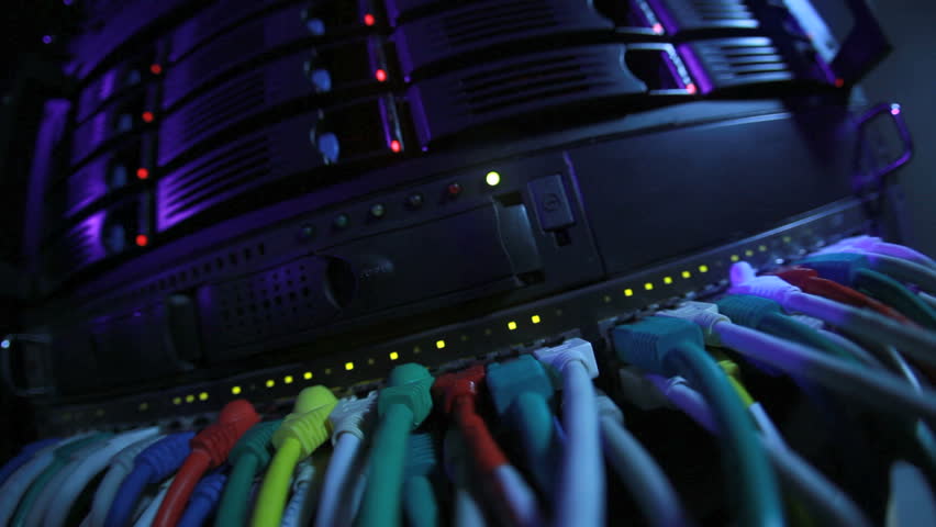 Server Rack and Network Hub cables with flickering lights toned in blue color through a fish-eye lense
