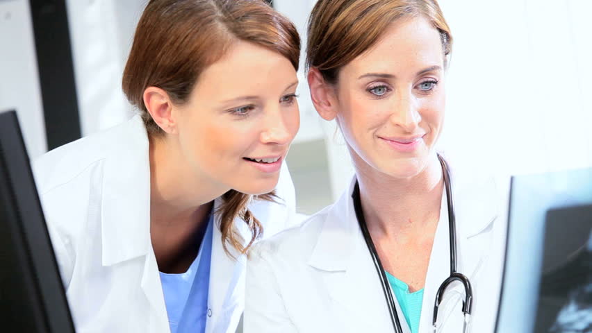 Full frame female medical clinicians pleased with treatment results from patient x-ray