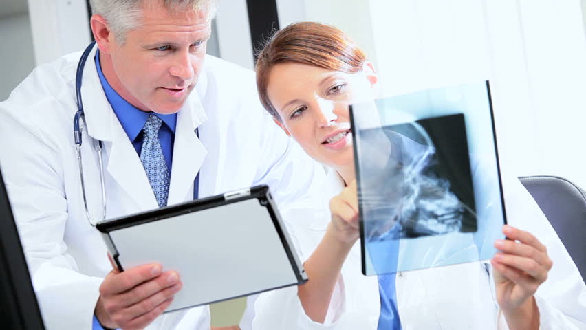 Hospital radiologist and doctor working with patient x-rays wireless tablet information