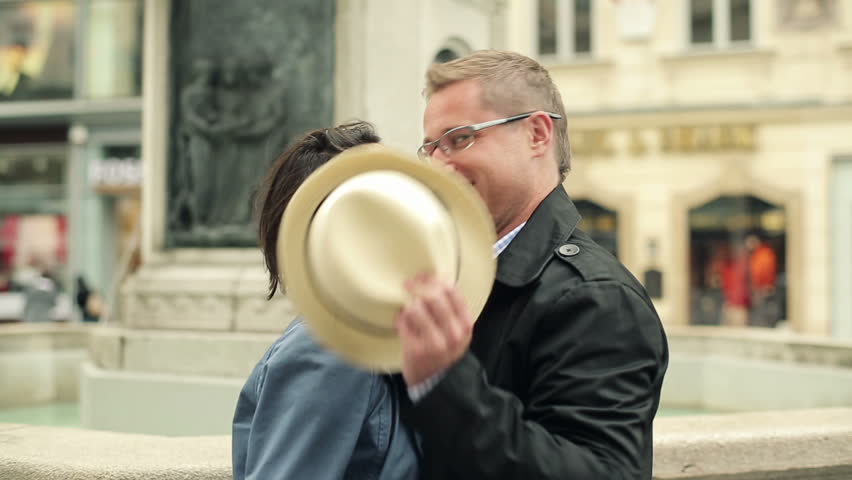 Couple of tourist kissing  behind a hat in the old town
