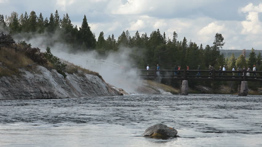 YELLOWSTONE NATIONAL PARK, WYOMING CIRCA 2009: One of the worlds most visited nature and geological parks. Historic river foot bridge . Tourists cross to geyser and hot springs.