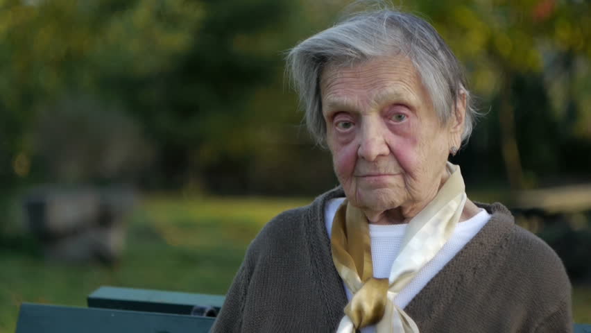 portrait of a very old lonely woman looking around hoping for some company